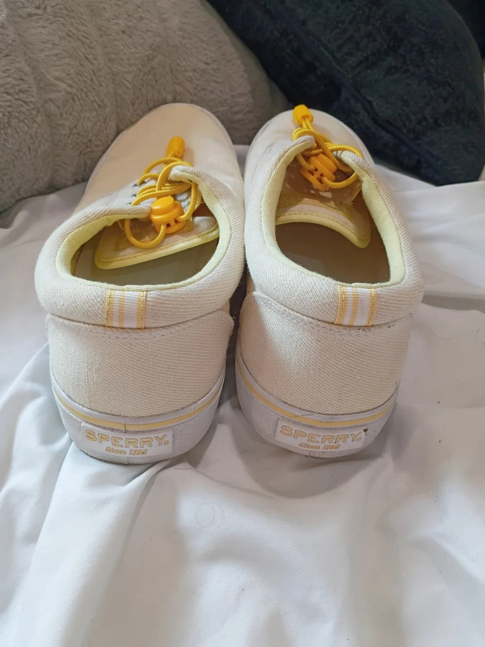 Yellow-tinged cream canvas sneakers are the Sperry Striper II CVO low-tops Sz 10